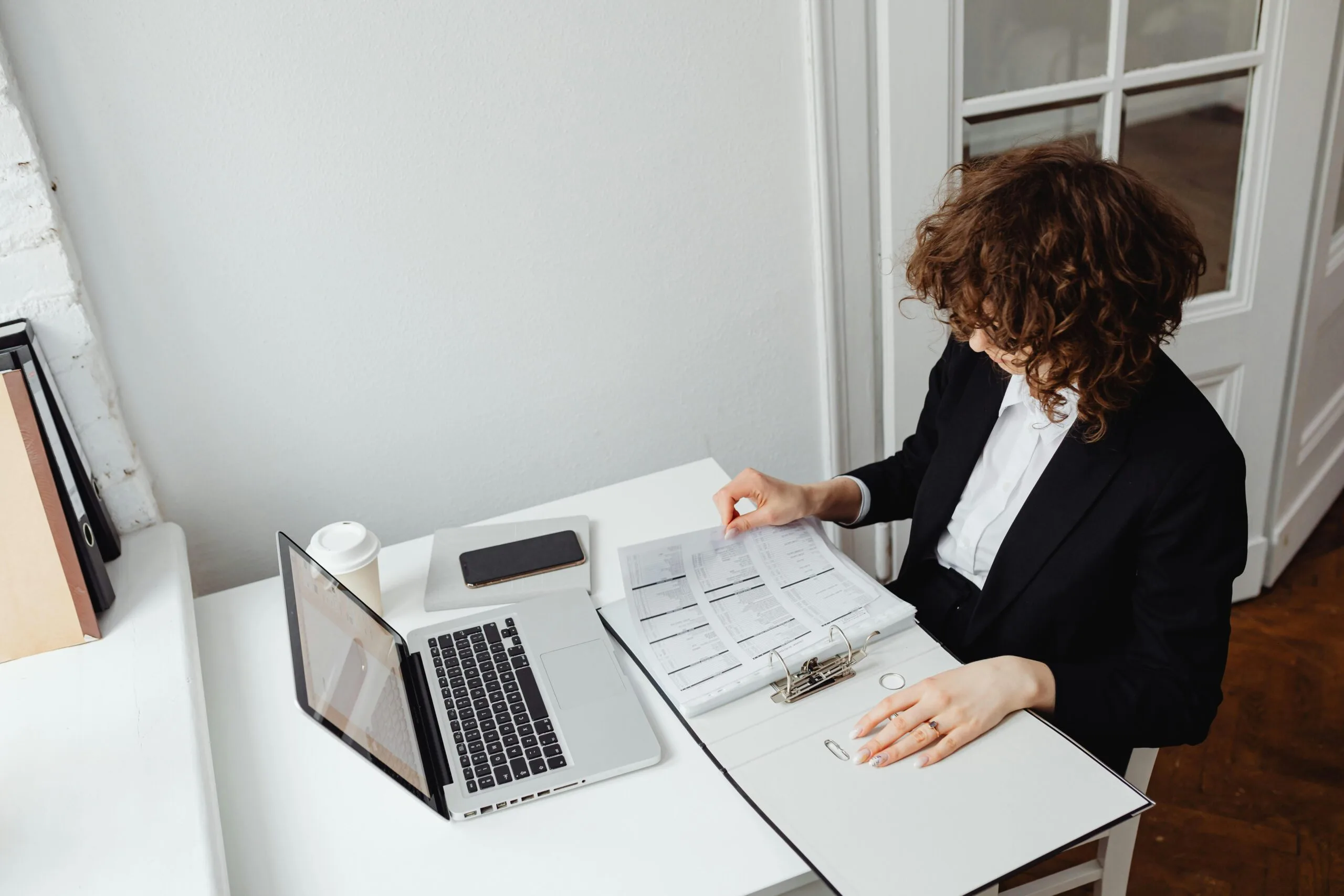A woman with her laptop, checking the papers
